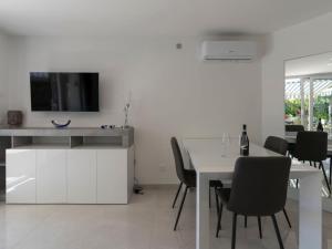 uma cozinha branca com uma mesa e uma televisão na parede em Apartment Bella Vista by Interhome em Bordighera