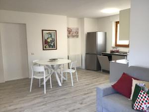 een woonkamer met een tafel en stoelen en een keuken bij Il Parco IUN R1207 - Ingresso indipendente con quattro posti letto in Santa Giusta