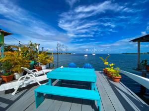 a blue bench sitting on a deck next to the water at Saigon Bay Bed & Breakfast in Bocas del Toro