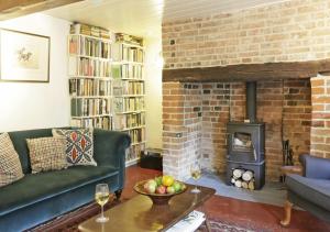 a living room with a couch and a fireplace at Sherfield Cottage in Snape