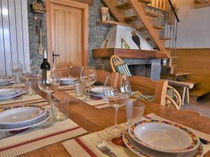 a table with glasses and plates and a bottle of wine at Chalet Baita Lake View in Poira di Dentro