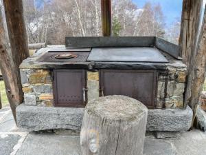 an outdoor brick oven with a stump next to it at Chalet Baita Lake View in Poira di Dentro