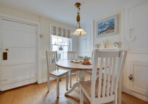 a white dining room with a table and chairs at Shrimpers in Southwold