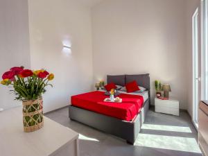 a bedroom with a red bed with a vase of flowers at Holiday Home Casa Luca by Interhome in Imperia +24 photos