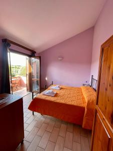 a bedroom with a bed and a balcony at I Puntoni Agriturismo in Magliano in Toscana