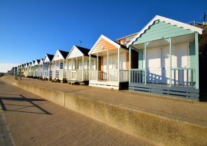 a row of beach huts on the side of a road at Skyes House in Southwold