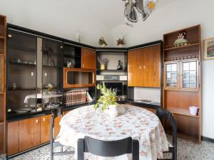 een keuken met een tafel met stoelen en kasten bij Apartment Gabri by Interhome in Pietrabruna