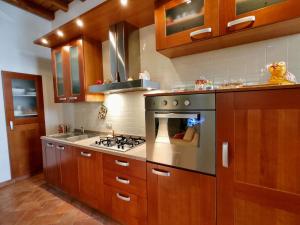 a kitchen with wooden cabinets and a stove top oven at Holiday Home La Cascina by Interhome in Lierna