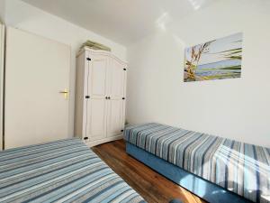 a bedroom with two beds and a painting on the wall at Ferienwohnung Leuchtturm in Sassnitz