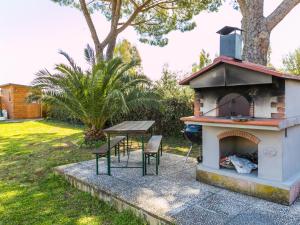 un horno al aire libre con 2 sillas y una mesa en Holiday Home La Casina by Interhome, en Bibbona