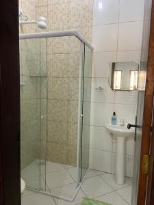 ein Bad mit einer Dusche und einem Waschbecken in der Unterkunft Casa agradável no centro in Bananeiras