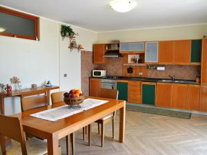 una cocina con una mesa de madera y un bol de fruta. en Apartment Piccolo Paradiso by Interhome, en Formia