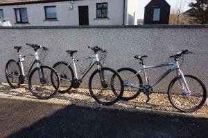 four bikes are parked next to a wall at Karrawa Guest House in Kirkwall