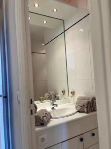 La salle de bains est pourvue d'un lavabo et d'un grand miroir. dans l'établissement NEWLY RENOVATED! Harbour View on Balcony Terrace, à Cannes