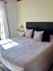 a large bed with two pillows on it in a bedroom at Duplex en Alquiler Pinamar in Pinamar +6 photos