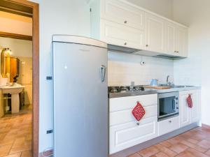  La cuisine est équipée de placards blancs et d'un réfrigérateur. dans l'établissement Apartment Lavender by Interhome, à Santa Luce