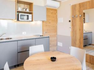 cocina con mesa de madera y armarios blancos en Apartment Panorama-2 by Interhome, en Costermano