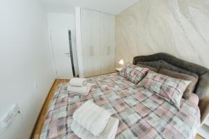 a bedroom with a bed with two towels on it at Vojvodjanska zora - besplatan parking in Sombor