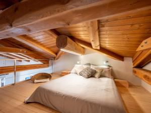 a bedroom with a large bed with wooden ceilings at Holiday Home Da Marita by Interhome in Verzuolo