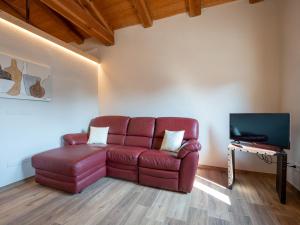 a living room with a red leather couch and a television at Holiday Home Da Marita by Interhome in Verzuolo