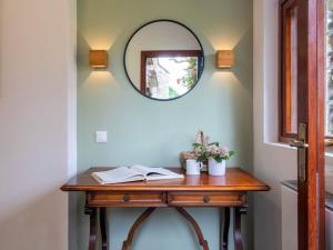 a wooden table with a mirror on a wall at Holiday Home Villa Camelia by Interhome in Porto Valtravaglia