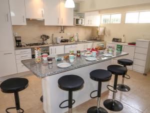 a kitchen with a counter with bar stools at Apartment Roy's place by Interhome in Portimão