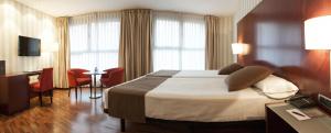 ein Hotelzimmer mit einem großen Bett und einem Schreibtisch in der Unterkunft Zenit Lleida in Lleida + 27 Fotos