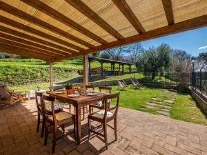 a wooden table and chairs on a patio at Holiday Home Civitella by Interhome in Scansano