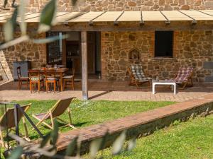 een patio met stoelen en een tafel en een gebouw bij Holiday Home Civitella by Interhome in Scansano