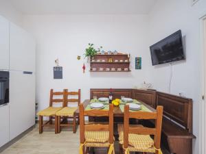 a dining room with a table and chairs and a television at Holiday Home Rita by Interhome in Torre del Lago Puccini
