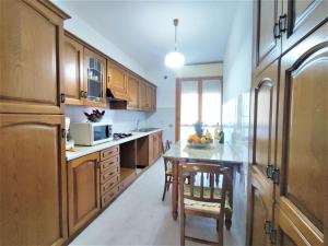 - une cuisine avec des placards en bois et une table avec des fruits dans l'établissement Apartment Casa Maccianti by Interhome, à Follonica