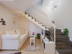 a living room with a white couch and stairs at Holiday Home Rita by Interhome in Torre del Lago Puccini