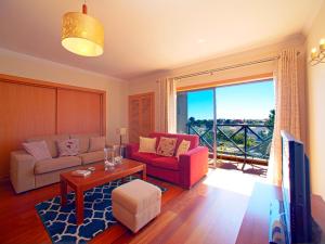 ein Wohnzimmer mit einem Sofa, einem Tisch und einem TV in der Unterkunft Apartment Sunflower by Interhome in Albufeira