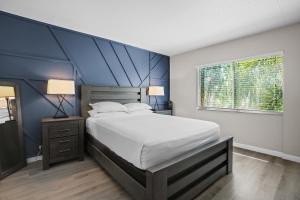 a bedroom with a large bed with a blue accent wall at Avenida in Tampa