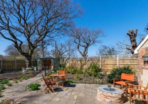a patio with chairs and tables and a fence at South Lodge in Corton