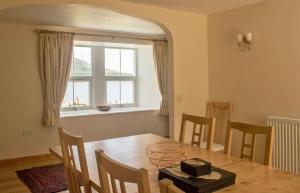 a dining room with a table and chairs and a window at Old School in Dunan