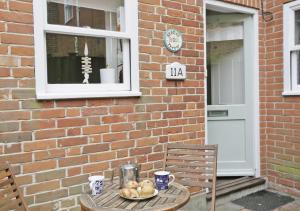 a table with a plate of food on it next to a brick building at Stones Throw in Southwold
