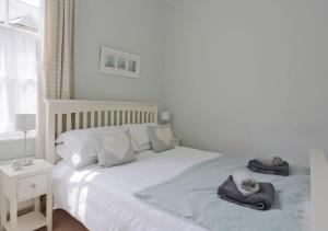a bedroom with a white bed with towels on it at Stones Throw in Southwold