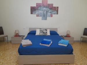 a bedroom with a blue bed with two pillows on it at B&B Renella in Caserta