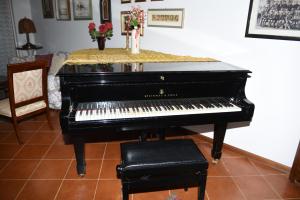un piano negro sentado en una sala con una mesa en Casa gialla nel bosco, en Reggello