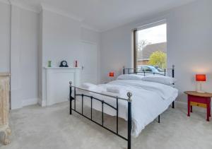 a white bedroom with a bed and a window at Stonehurst in Aldringham