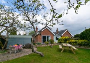 a garden with a picnic table and a house at Stonehurst in Aldringham