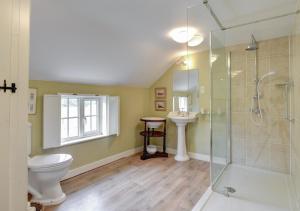 a bathroom with a shower and a toilet and a sink at Boot Cottage in Sudbourne