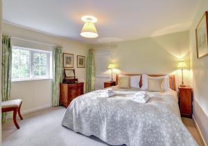 a bedroom with a large bed with two towels on it at Boot Cottage in Sudbourne