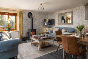 sala de estar con sofá azul y chimenea en Cuckoo Cottage - Luxury Cottages, en Ilfracombe