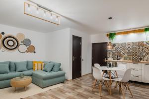 a living room with a blue couch and a table at CoZee Studio - In inima Brasovului in Braşov