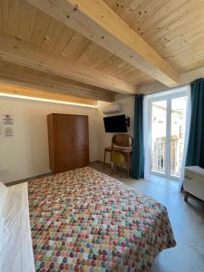 a bedroom with a large bed and a large window at De LoCa Rooms in Tropea