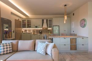 a living room with a couch and a kitchen at AVAL Riviera in Lagonissi
