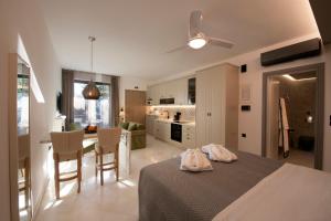 Cet appartement comprend une chambre avec un lit et une cuisine avec une table. dans l'établissement AVAL Riviera, à Lagonissi