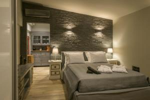 a bedroom with a bed and a brick wall at AVAL Riviera in Lagonissi